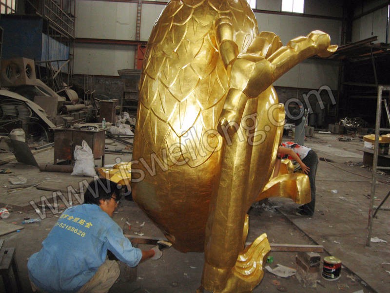我公司金艺师父正在为贴金完成后的龙雕表面做保护。